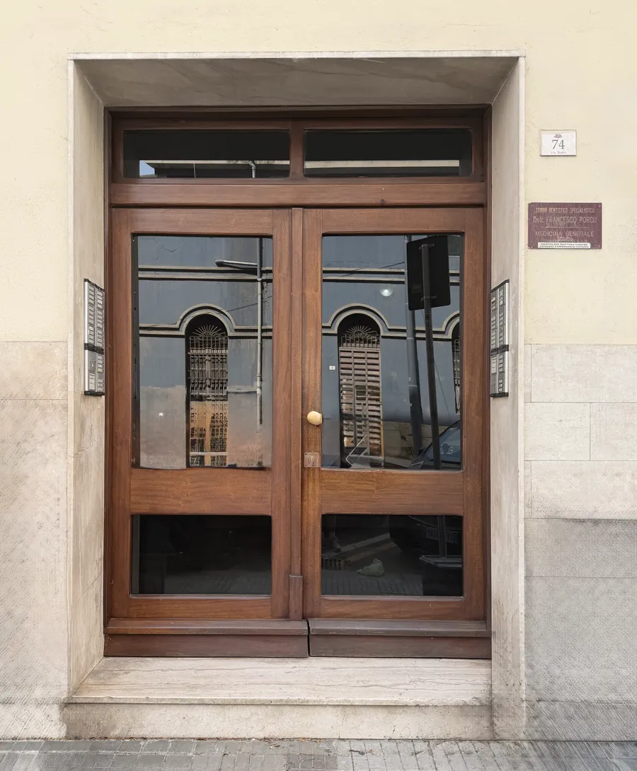 Il portone in legno di Via Roma 74, con la targa dello studio